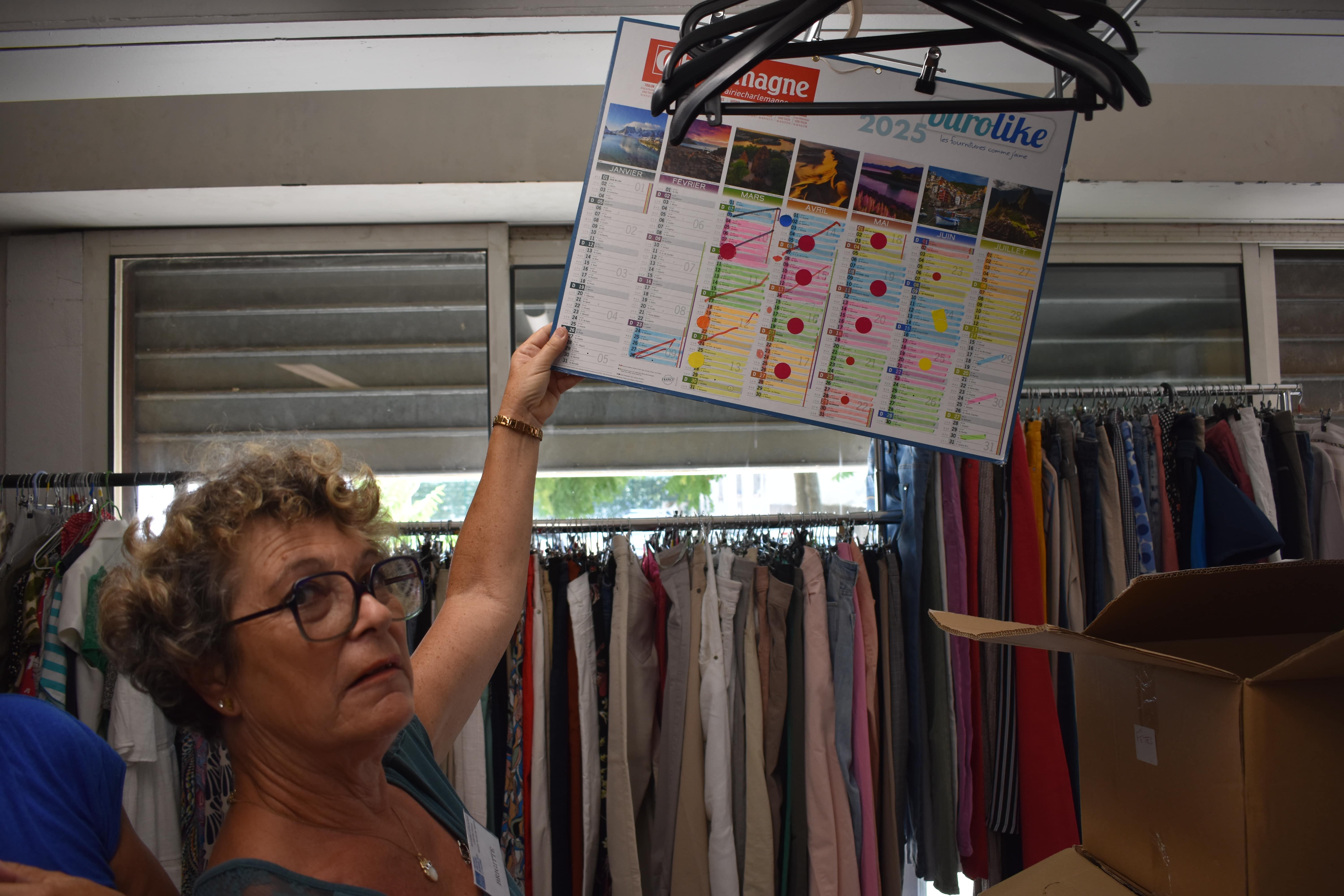 Une bénévole montre le calendrier des réassorts